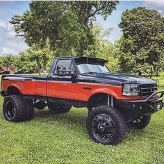 an orange and black truck parked in the grass