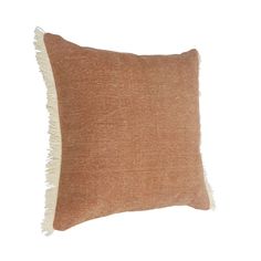 a brown and white pillow with fringes on the side, against a white background