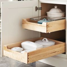 an open drawer in a kitchen next to a sink