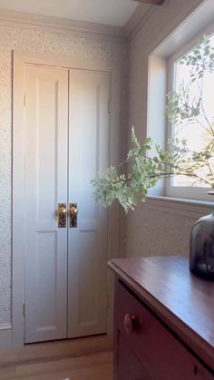 an empty room with a vase on the dresser