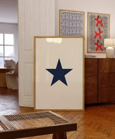 there is a large blue star on the wall next to two framed pictures and a wooden table