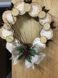 a wreath made out of wood slices and pine cones