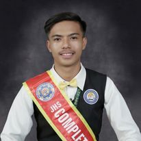 a man wearing a sash and smiling for the camera