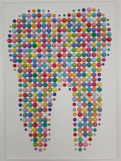 an art piece made out of colorful circles and dots in the shape of a tooth