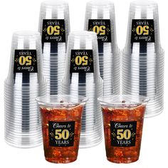 plastic cups with black and gold 50th anniversary labels on them are set up in rows