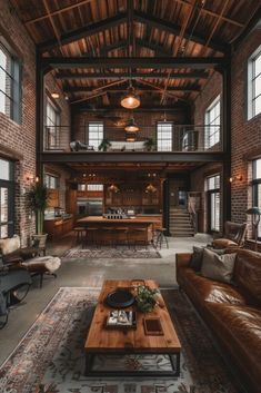 a living room filled with lots of furniture next to large windows and wooden beams on the ceiling