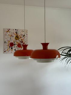 two red lamps hanging from a ceiling in a room