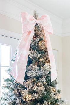 a decorated christmas tree with pink and white bows