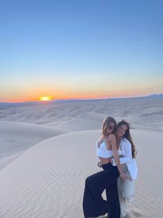 two girls at dan dunes at sunrise posing for the photo. one girl wears a while crochet top with float brown pants and the other wears a white button up Imperial Sand Dunes Photoshoot, Sand Dune Outfits, Dunes Photoshoot, Imperial Sand Dunes, Lake Pics