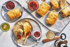 there are many pastries on the table with dipping sauces and condiments