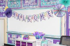 a classroom decorated with purple and green decorations for the welcome home sign on the wall