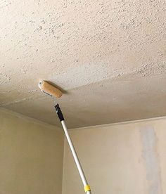 a mop is hanging from the ceiling in a room that has been painted white