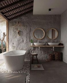 a white bath tub sitting next to a sink in a bathroom on top of a stone floor