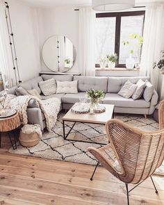 a living room filled with furniture and a large mirror on the wall above it's windows