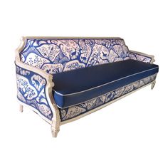 a blue and white couch sitting on top of a wooden frame