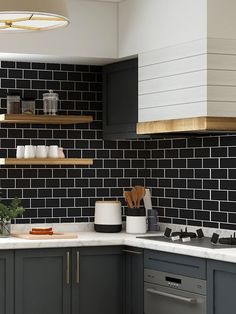 a kitchen with black and white tiles on the wall