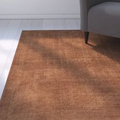 a living room with a chair and rug on the floor