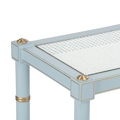 a blue table with gold trimmings and a glass top