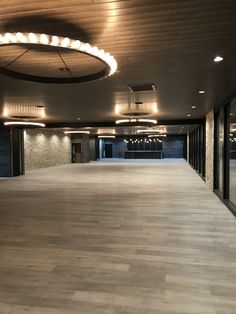 an empty room with wooden floors and round lights