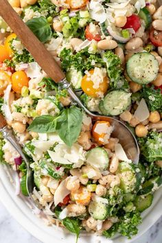 a salad with broccoli, chickpeas and cucumbers in it