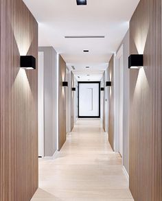 the hallway is lined with wooden panels and black lights on either side of the door