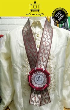 a white shirt with a red ribbon around it and a badge attached to the collar