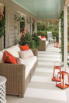 a porch with wicker furniture and christmas decorations on the front porch, along with greenery