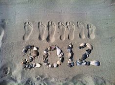 the word love written in sand with rocks and shells