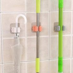 two green and white umbrellas hanging on the wall next to each other in a bathroom