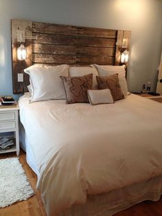 a bed with white linens and pillows in a bedroom next to a night stand