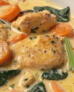 a white bowl filled with chicken, carrots and spinach in gravy