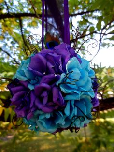 a purple and blue bouquet hanging from a tree