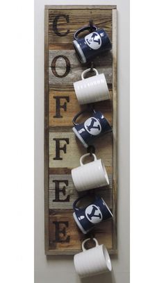 three cups are hanging on the wall with coffee mugs attached to each cup holder