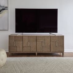 a flat screen tv sitting on top of a wooden cabinet in front of a painting