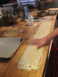 a person is rolling dough on a wooden counter