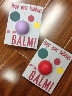 two greeting cards with balls hanging from strings and the words hope your holidays are the balm