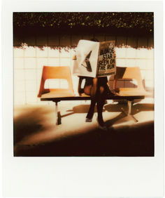 a person sitting on a bench holding a sign