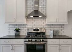 a stove top oven sitting inside of a kitchen next to white cabinets and counter tops