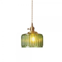 a green glass pendant light hanging from a ceiling fixture with a gold chain attached to it