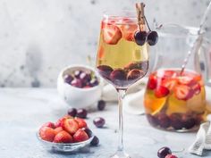 two glasses of wine and some fruit on a tray