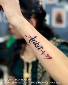 a woman with a tattoo on her arm that says aritrina in cursive writing