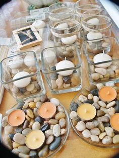 candles and rocks in glass containers on a table