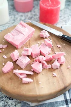 pieces of pink fudge sitting on top of a wooden cutting board