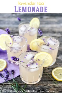 three glasses filled with lavender lemonade on top of a wooden table next to sliced lemons