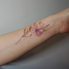 a woman's arm with a flower tattoo on it