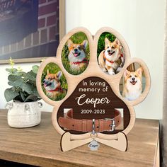 a dog's paw with three photos on it and a wooden plaque that says in loving memory of cooper 2009 - 2012