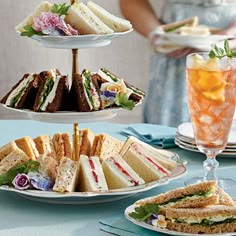 three tiered plates with sandwiches and drinks on them