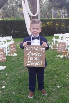 a young boy holding up a sign that says don't worry ladies i'm still single