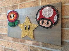 two handmade items are displayed on a wood plaque with a star, mushroom and flower