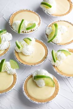 several small pies with lime and whipped cream on them